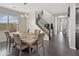 Elegant dining room with modern chandelier, dark floors, stairway and view into the entryway at 12227 W Prickly Pear Trl, Peoria, AZ 85383
