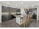 Open kitchen featuring dark cabinetry, granite countertops, stainless steel appliances, and kitchen island with barstool seating at 12227 W Prickly Pear Trl, Peoria, AZ 85383