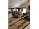 Open concept living area with tile flooring, plush rug, and kitchen views at 12565 W Amelia Ave, Avondale, AZ 85392
