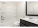 Well-lit bathroom featuring a shower-tub combo, vanity with black framed mirror, and tile flooring at 12673 W Myrtle Ave, Glendale, AZ 85307