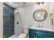 Modern bathroom with vanity with teal cabinets, gold hardware, and glass-enclosed shower at 12809 E Sahuaro Dr, Scottsdale, AZ 85259