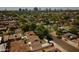Aerial view of a residential neighborhood with tree-lined streets, cozy homes, and a clear view of the cityscape beyond at 1301 E Sheridan St, Phoenix, AZ 85006