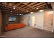 Finished basement with an orange sofa, carpeted floors and a TV with an outdoor scene at 1301 E Sheridan St, Phoenix, AZ 85006