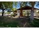 Charming single-story home with a brick chimney, white siding, well-manicured lawn, mature shade trees and a front porch at 1301 E Sheridan St, Phoenix, AZ 85006