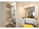 Bright bathroom featuring a vanity, large mirror, and a walk-in shower with glass doors at 13640 N Del Webb Blvd, Sun City, AZ 85351