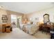Spacious bedroom with patio access, twin beds, and a classic writing desk with chair at 13640 N Del Webb Blvd, Sun City, AZ 85351