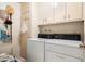 Well-lit laundry room featuring modern washer and dryer units, and ample storage cabinets at 13640 N Del Webb Blvd, Sun City, AZ 85351