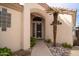 Inviting front entrance with a security screen door, lush landscaping and a palm tree at 14130 W Bent Tree Cir, Litchfield Park, AZ 85340