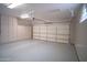 Clean garage with an epoxy floor, cabinets, and updated lighting at 14130 W Bent Tree Cir, Litchfield Park, AZ 85340