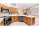 Bright kitchen with stainless steel appliances, wood cabinets, tile floors and a large island with sink at 14130 W Bent Tree Cir, Litchfield Park, AZ 85340