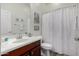 Bathroom features wood vanity, patterned shower curtain, and neutral color palette at 15062 W Windward Ave, Goodyear, AZ 85395