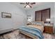 Cozy bedroom featuring plantation shutters, ceiling fan, and wood-look floors at 15062 W Windward Ave, Goodyear, AZ 85395