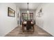 Dining room with a long table, seating for six, modern lighting, and wood-style flooring at 15062 W Windward Ave, Goodyear, AZ 85395