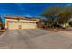 Single-story home boasts a three-car garage, desert landscaping, and neutral exterior at 15062 W Windward Ave, Goodyear, AZ 85395