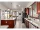 Kitchen with island, granite counters, stainless appliances, and a view to the backyard at 15062 W Windward Ave, Goodyear, AZ 85395