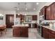 Spacious kitchen with a central island, stainless steel appliances, and stylish dark wood cabinetry at 15062 W Windward Ave, Goodyear, AZ 85395