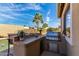Outdoor kitchen and bar area with a built-in grill and under-counter storage at 15062 W Windward Ave, Goodyear, AZ 85395