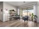 Bright sitting room with wood tile flooring, plants, and sliding glass doors overlooking the backyard pool at 15062 W Windward Ave, Goodyear, AZ 85395