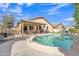 A backyard paradise boasts a sparkling pool, covered patio, and playset on the artificial turf for endless fun and relaxation at 16847 W Marconi Ave, Surprise, AZ 85388