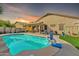 This backyard features a sparkling pool, covered patio, and lush green lawn, perfect for outdoor enjoyment and relaxation at 16847 W Marconi Ave, Surprise, AZ 85388