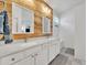 Bathroom featuring a double vanity, decorative wood wall, modern lighting, and a large walk-in shower at 16847 W Marconi Ave, Surprise, AZ 85388