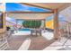 Inviting covered patio with an outdoor dining set, barbecue, and relaxing lounge area overlooking the sparkling pool at 16847 W Marconi Ave, Surprise, AZ 85388