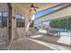 A spacious covered patio with rocking chairs and a dining set provides ample space for outdoor entertaining at 16847 W Marconi Ave, Surprise, AZ 85388