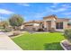 A beautiful single-story home with well-maintained landscaping and a manicured lawn at 16847 W Marconi Ave, Surprise, AZ 85388