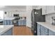 Kitchen features modern stainless appliances, a gas cooktop, and white and blue cabinets at 16847 W Marconi Ave, Surprise, AZ 85388