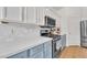 Modern kitchen featuring stainless steel appliances, gas range, and white marble backsplash at 16847 W Marconi Ave, Surprise, AZ 85388