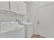 Functional laundry room with washer, dryer, and overhead storage cabinets at 16847 W Marconi Ave, Surprise, AZ 85388