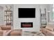 Modern living room with a sleek fireplace, wall-mounted TV, and stylish decor at 16847 W Marconi Ave, Surprise, AZ 85388