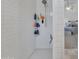 Modern shower with white subway tile, convenient shelving, and updated fixtures at 16847 W Marconi Ave, Surprise, AZ 85388