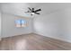 Minimalist bedroom with hardwood floors, ceiling fan, white walls, and a large window with blinds at 1700 E Lakeside Dr # 16, Gilbert, AZ 85234