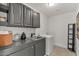 Laundry room with gray cabinets, black hardware, and modern appliances at 1700 E Lakeside Dr # 16, Gilbert, AZ 85234