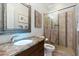 Bathroom with a granite countertop, lighted sink, framed mirror, and a glass enclosed shower with neutral-colored tiles at 17773 N 77Th Way, Scottsdale, AZ 85255
