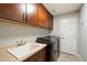 Efficient laundry room with modern washer and dryer, ample cabinet space, and a convenient sink for added functionality at 17773 N 77Th Way, Scottsdale, AZ 85255