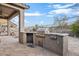 Outdoor kitchen area with built-in BBQ and desert landscape views at 18391 W Verdin Rd, Goodyear, AZ 85338