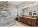 Dual sink bathroom boasting a glass shower with decorative stone floor at 18391 W Verdin Rd, Goodyear, AZ 85338