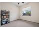 A carpeted bedroom with a window and a black bookshelf filled with books at 18391 W Verdin Rd, Goodyear, AZ 85338
