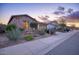 Attractive stone home exterior with desert landscaping and a well-manicured lawn at 18391 W Verdin Rd, Goodyear, AZ 85338