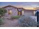 Charming stone exterior, desert landscaping, and an attached two-car garage at 18391 W Verdin Rd, Goodyear, AZ 85338