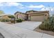 Attractive stone house with a two-car garage and lush desert landscaping at 18391 W Verdin Rd, Goodyear, AZ 85338