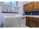 The laundry room has matching washer and dryer, blue walls and cabinets at 18391 W Verdin Rd, Goodyear, AZ 85338
