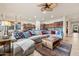 Open-concept living room featuring a large sectional sofa, ceiling fan, and seamless flow into the kitchen at 18391 W Verdin Rd, Goodyear, AZ 85338