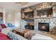 Comfortable living room with a stone fireplace, television, and a cozy sectional sofa at 18391 W Verdin Rd, Goodyear, AZ 85338