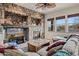 Comfortable living room with a stone fireplace, large windows, and plush seating at 18391 W Verdin Rd, Goodyear, AZ 85338