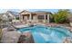 Backyard pool includes rock waterfall features and lush desert landscaping at 18391 W Verdin Rd, Goodyear, AZ 85338