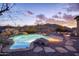 Backyard pool with rock features, desert landscaping, and picturesque mountain views at 18391 W Verdin Rd, Goodyear, AZ 85338