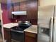 Kitchen featuring dark cabinetry, updated appliances, and ample counter space at 1858 N Hibbert Cir, Mesa, AZ 85201